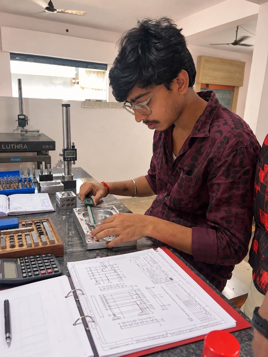 Varun Industries engineer inspecting a precision machined housing with digital vernier calipers against technical drawings