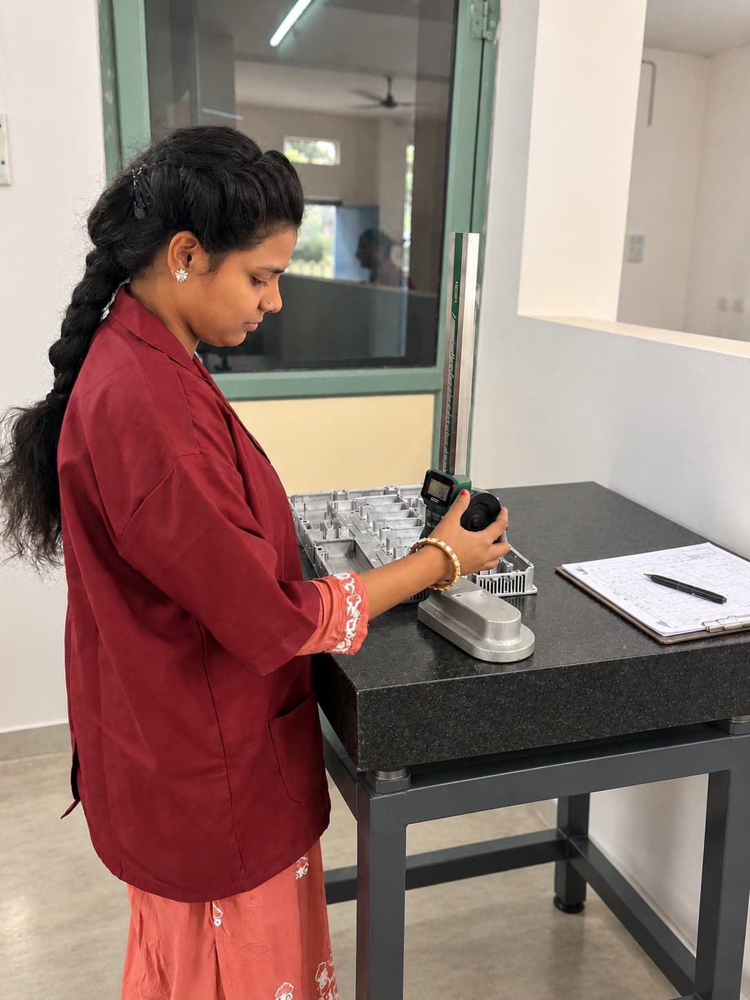 Varun Industries engineer measuring a precision milled enclosure using a digital height gauge on a granite surface plate